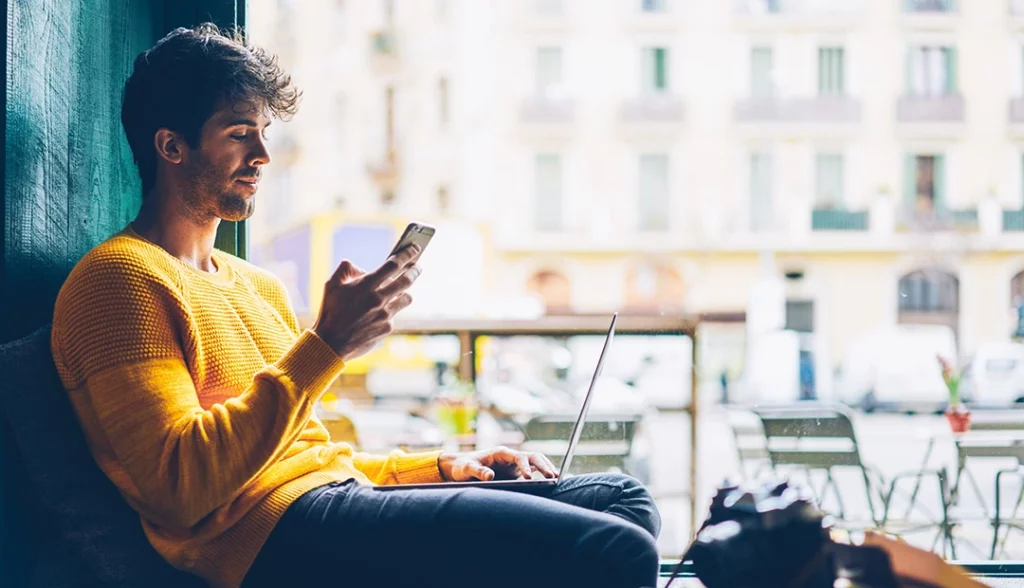jovem no telefone a analisar a sua reputação online