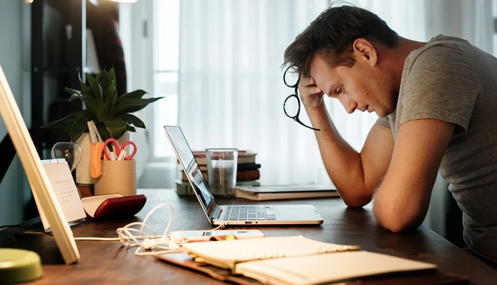 homem frustrado ao computador com síndrome do impostor
